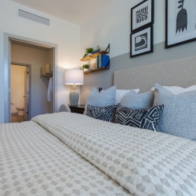 Sleep in style A bedroom with upholstered headboard and beige bedding.